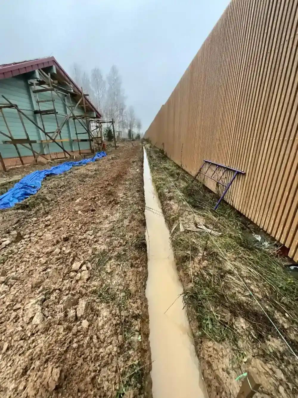 Переувлажнённый грунт в траншее у здания